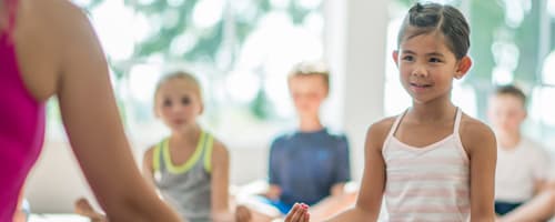 Crianças praticam ioga nas aulas de Educação Física